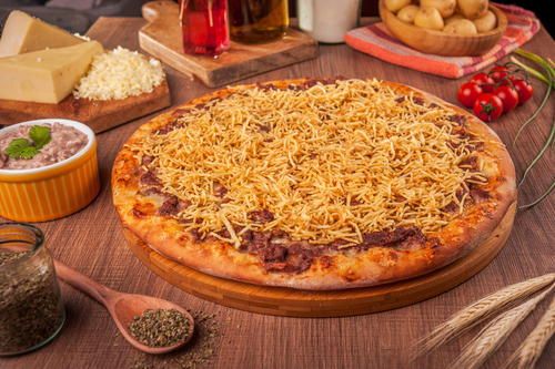 Na imagem, há uma pizza de strogonoff com batata palha