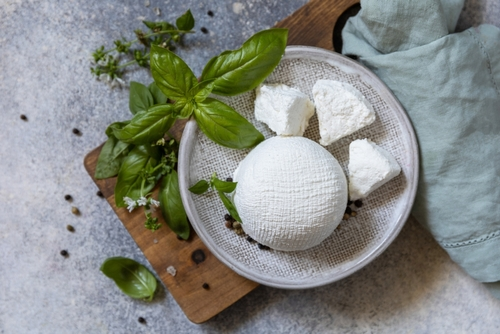 Na imagem, há um prato cinza com pedaços de queijo ricota