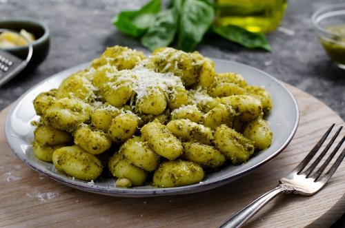 Na imagem, há um prato com nhoque ao molho pesto