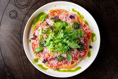 Na imagem, há um prato com carpaccio de tomate