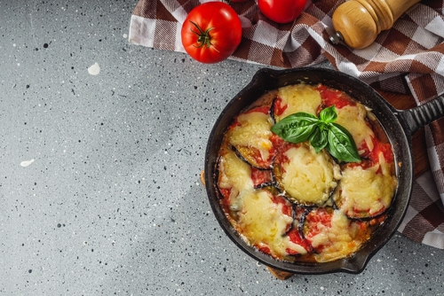 Na imagem, há um prato fundo com berinjela à parmegiana